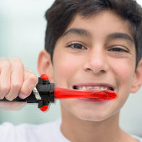 Child brushing teeth with Firefly Star Wars Red Lightsaber toothbrush