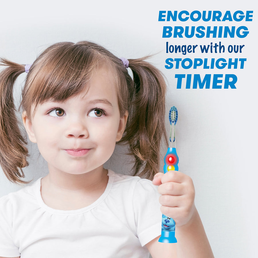 Child holding Blue's Clues light up timer toothbrush. Encourage brushing longer with our stoplight timer